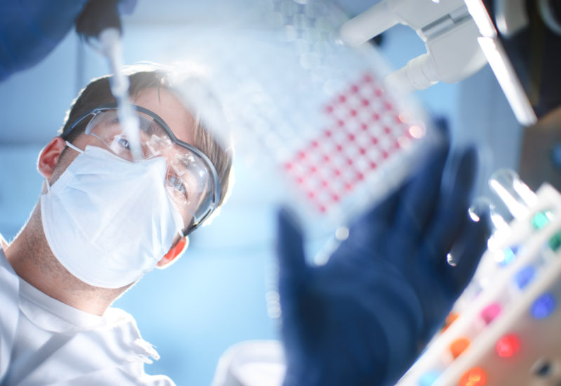 A scientist utlilizing a microplate