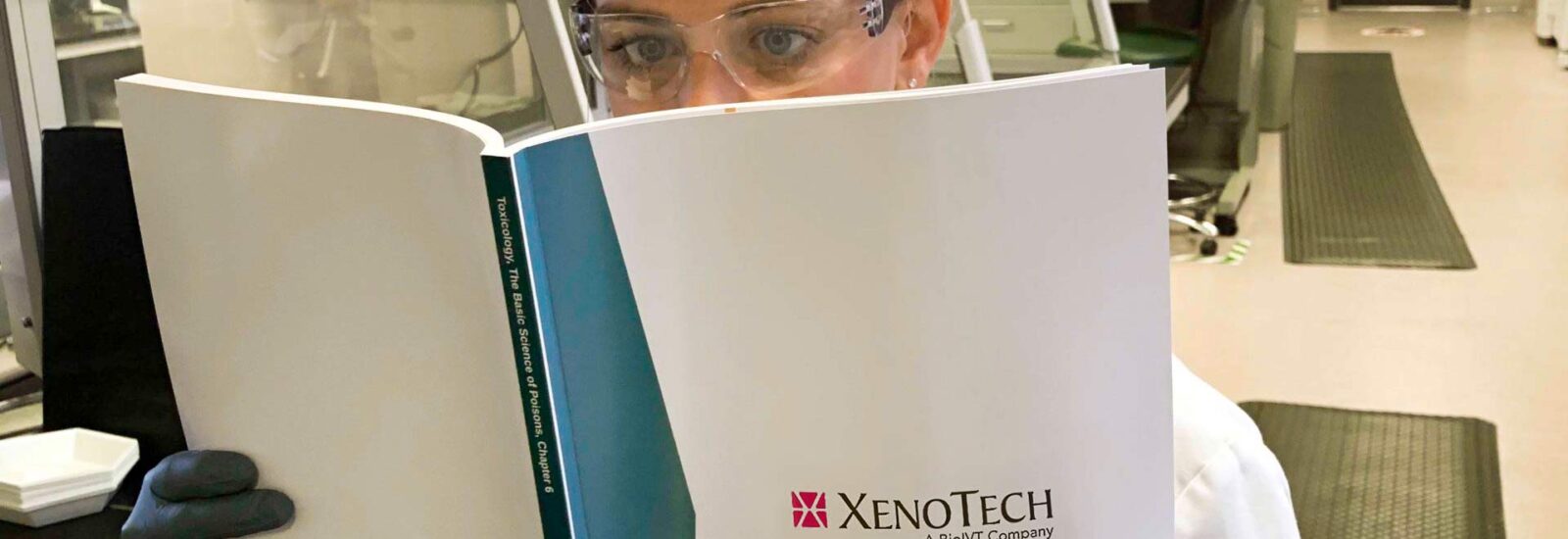 Lab researcher reading Xenotech biotransformation of xenorobotics book